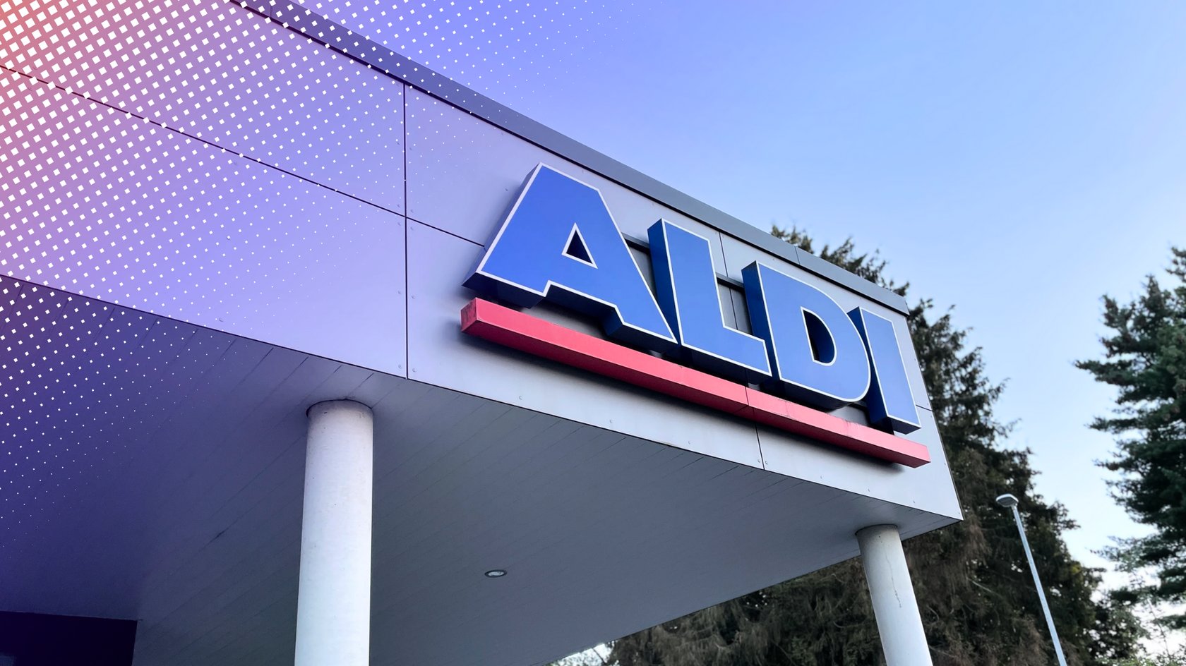 Ein Aldi-Logo in blauen Buchstaben mit einem roten Unterstrich, angebracht an der modernen Fassade eines Gebäudes, vor einem klaren Himmel und Bäumen im Hintergrund. Ein Aldi-Logo in blauen Buchstaben mit einem roten Unterstrich, angebracht an der modernen Fassade eines Gebäudes, vor einem klaren Himmel und Bäumen im Hintergrund.