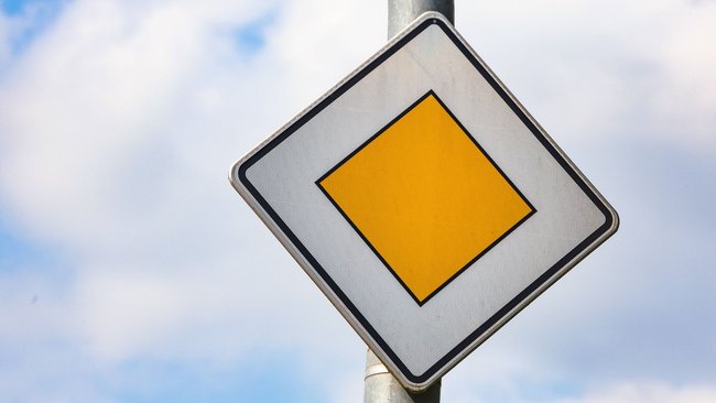 Ein Verkehrsschild für Vorfahrtstraßen vor bewölktem Himmel. Ein Verkehrsschild für Vorfahrtstraßen vor bewölktem Himmel.