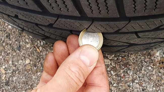 Messung der Profiltiefe eines Reifens mithilfe einer Euro-Münze. Messung der Profiltiefe eines Reifens mithilfe einer Euro-Münze.