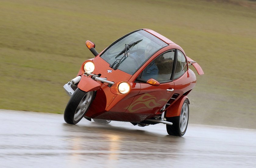 Roter Caver fährt auf nasser Straße Roter Caver fährt auf nasser Straße