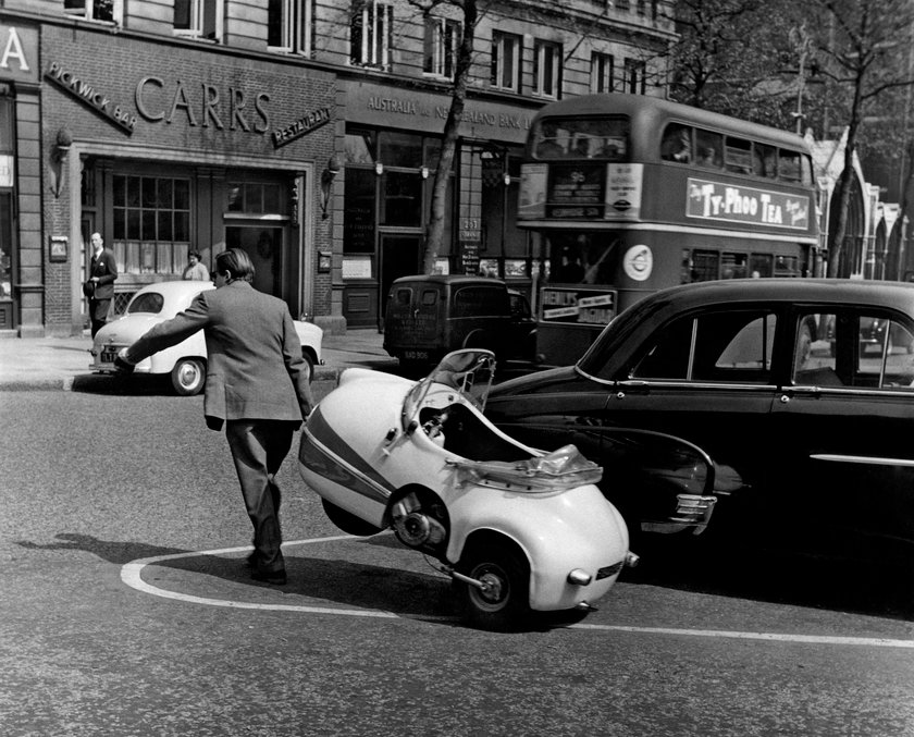 Mann zieht sehr kleines Auto hinter sich her Mann zieht sehr kleines Auto hinter sich her