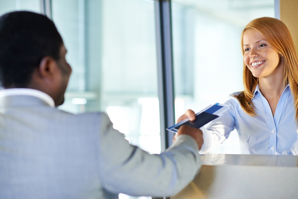 Attractive young woman giving passport and ticket