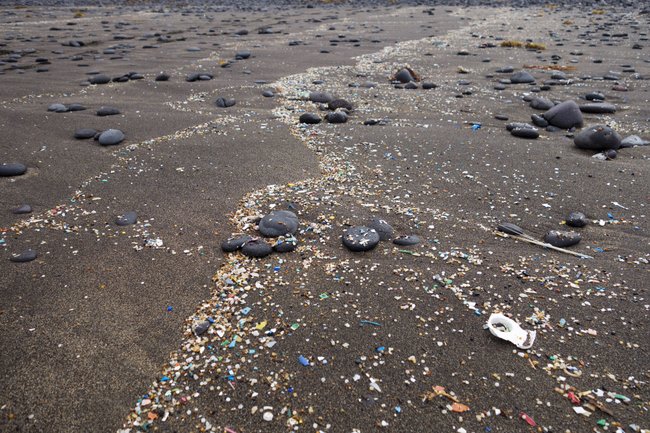 An einem Strand wird Mikroplastik angespült.