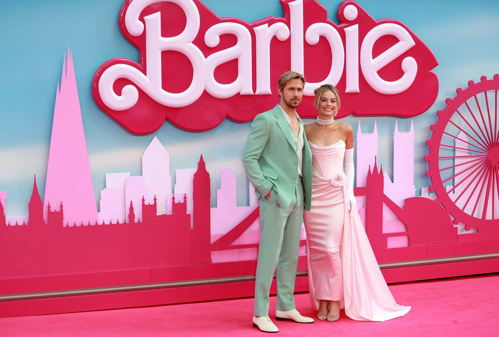 Vor einem Barbie-Banner auf dem roten Teppich stehen Margot Robbie und Ryan Gosling. Vor einem Barbie-Banner auf dem roten Teppich stehen Margot Robbie und Ryan Gosling.