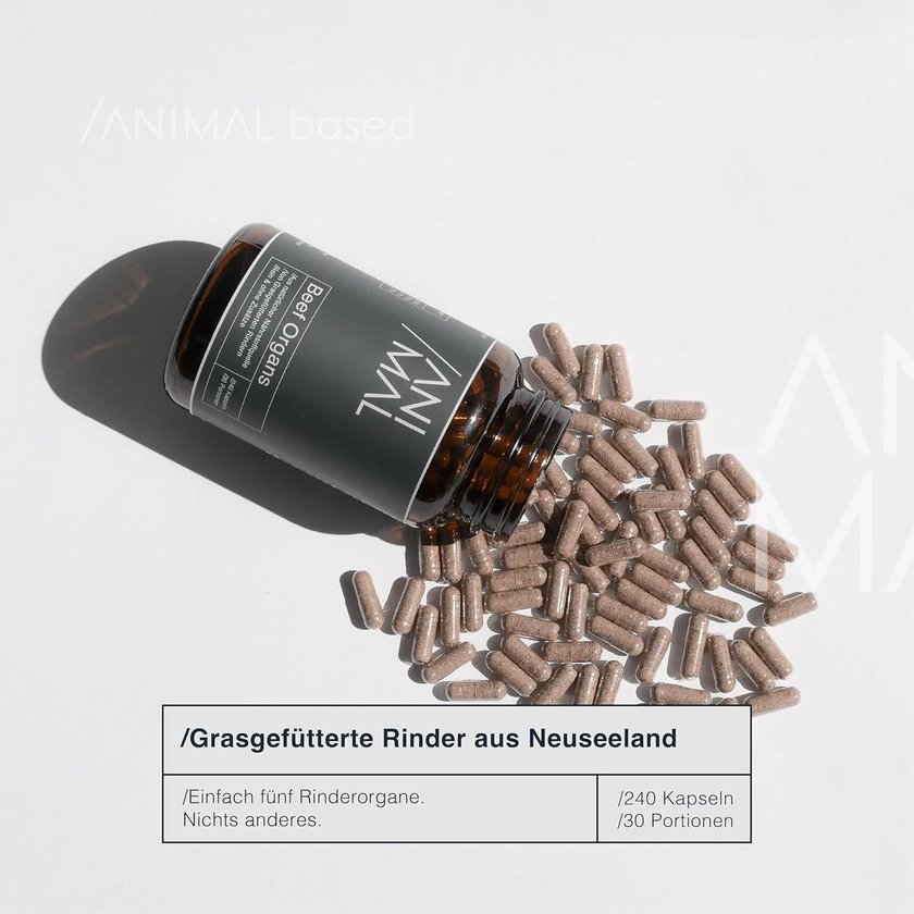 Eine braune Dose mit der Aufschrift "Animal Organs" und dem Text "Grasgefütterte Rinder aus Neuseeland" liegt auf einem Tisch, umgeben von vielen braunen Kapseln.