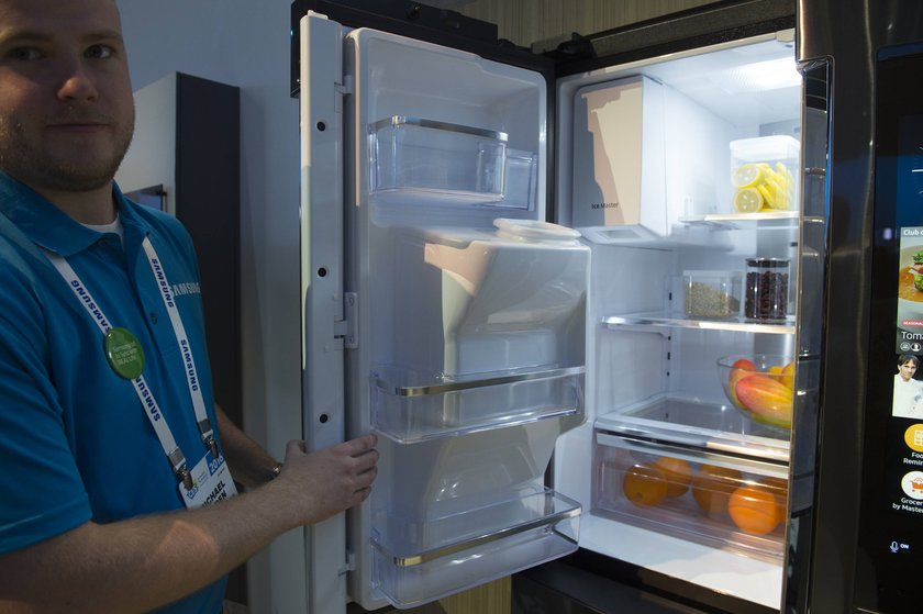 Mann steht vor Samsung Family Hub Kühlschrank