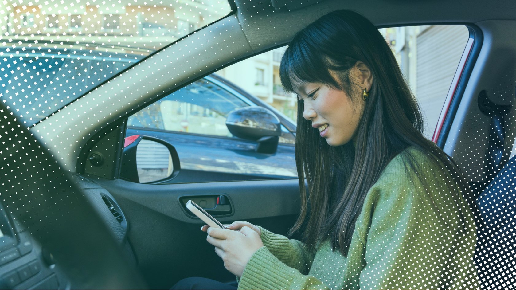 Frau sitzt mit iPhone im Auto.