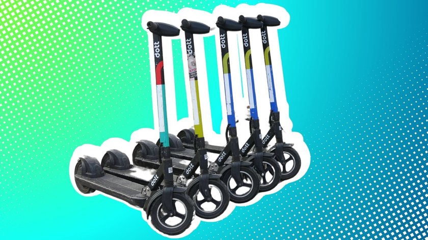 Fünf E-Scooter der Marke Dott stehen in einer Reihe.