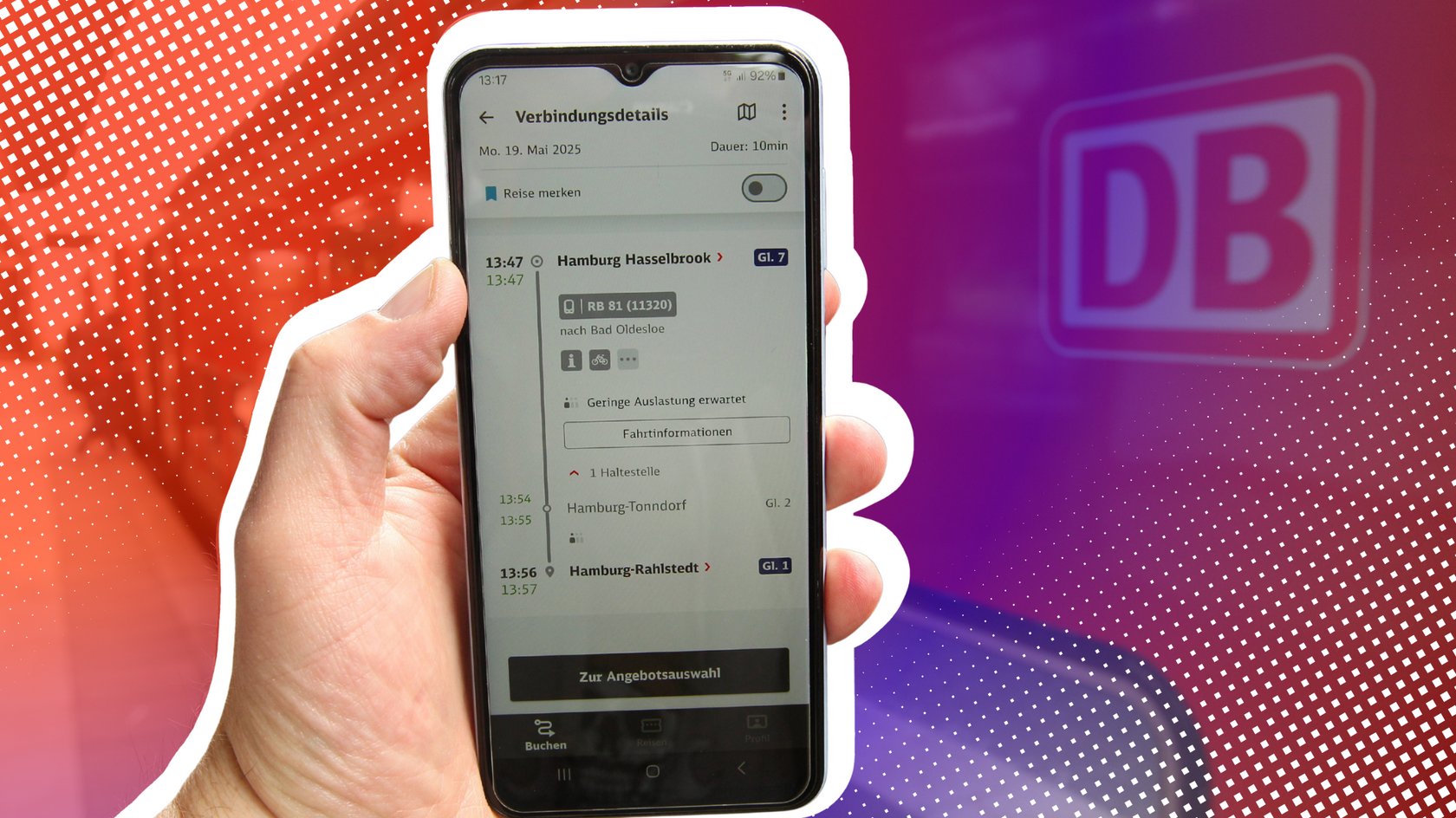 Smartphone mit Bahn-App vor einem Zug der DB