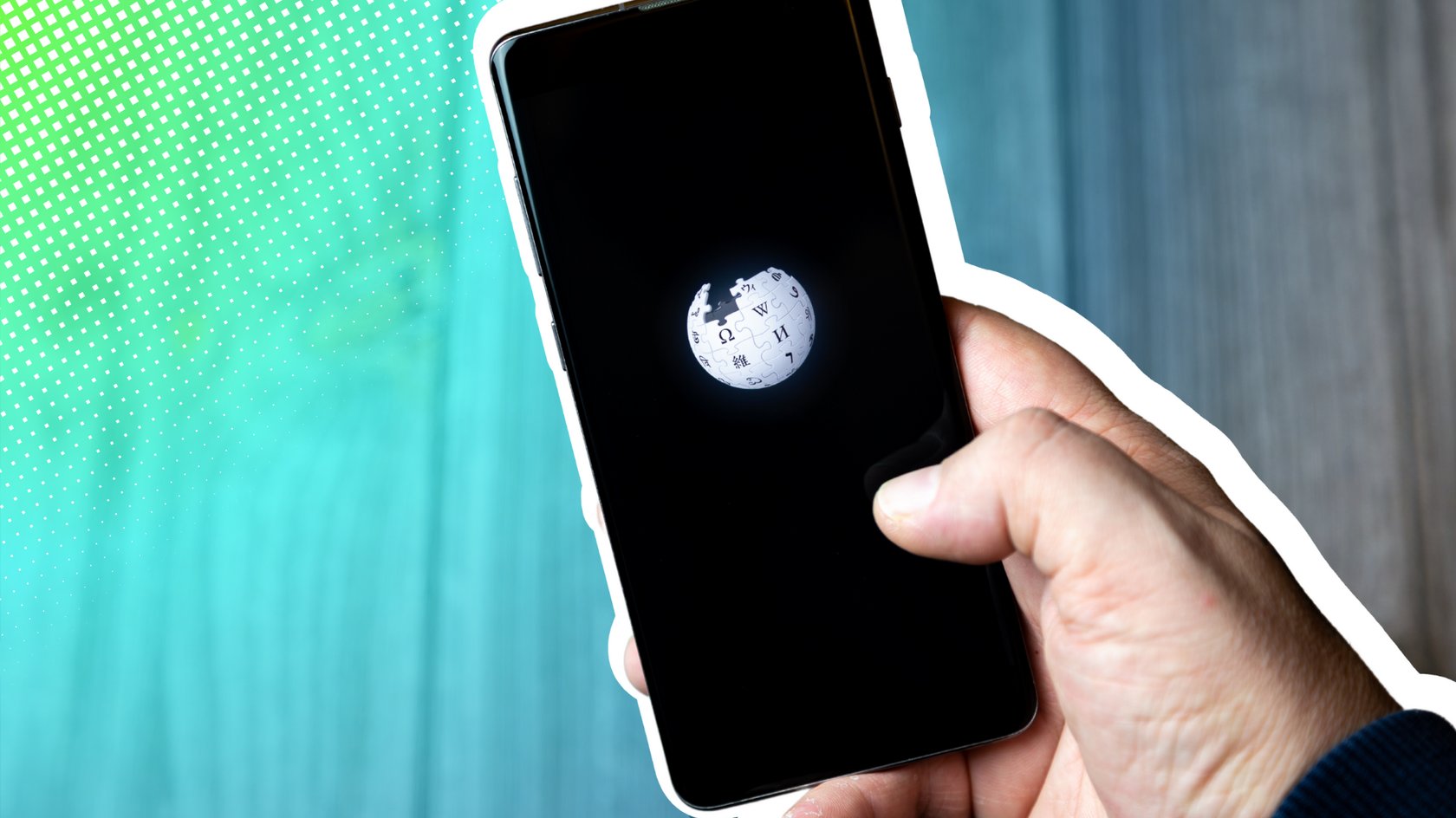 Nahaufnahme einer Hand, die ein Smartphone hält, auf dem Bildschirm das Wikipedia-Logo auf schwarzem Hintergrund. Der Hintergrund des Bildes ist links mit einem grünen und blauen Farbverlauf mit Rasterpunkten gestaltet, während rechts ein verschwommener, grauer Bereich sichtbar ist.