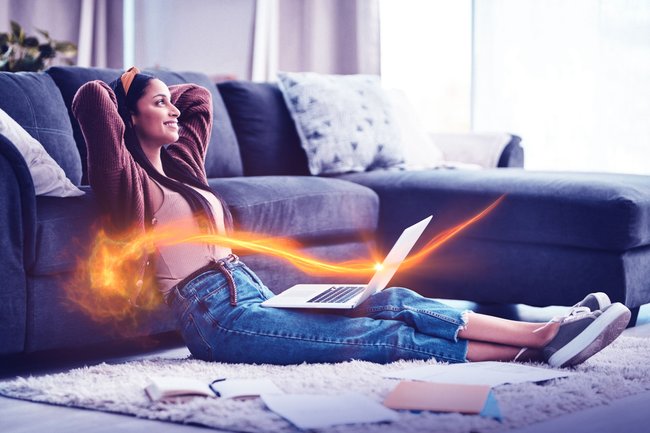 Shot of a young woman relaxing while working in the living room at home