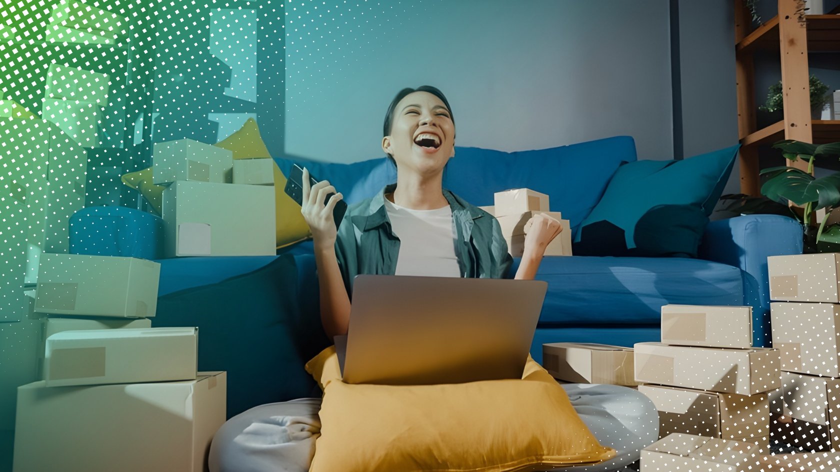 Frau sitzt for Laptop im Wohnzimmer, umgeben von Paketen und freut sich