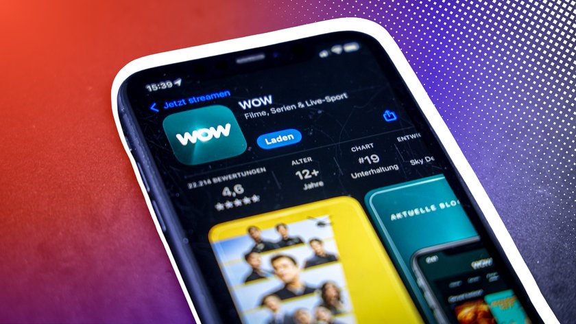 Ein Smartphone zeigt den App-Store-Eintrag der Streaming-Plattform "WOW" mit dem Slogan "Filme, Serien & Live-Sport". Der Bildschirm zeigt die Option "Laden" sowie eine Bewertung von 4,6 Sternen. Im Hintergrund ist ein roter und violetter Farbverlauf zu sehen.