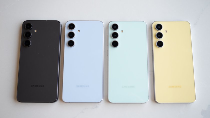 Vier Samsung-Galaxy-Handys, die nebeneinander auf einem Tisch liegen und unterschiedliche Farben haben.