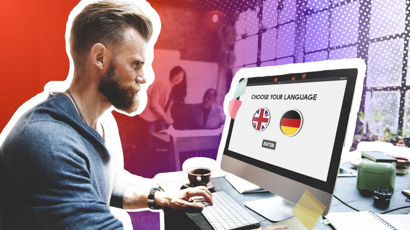 Bärtiger Mann schaut auf PC (Mac) und wählt zwischen den Sprachen Deutsch und Englisch