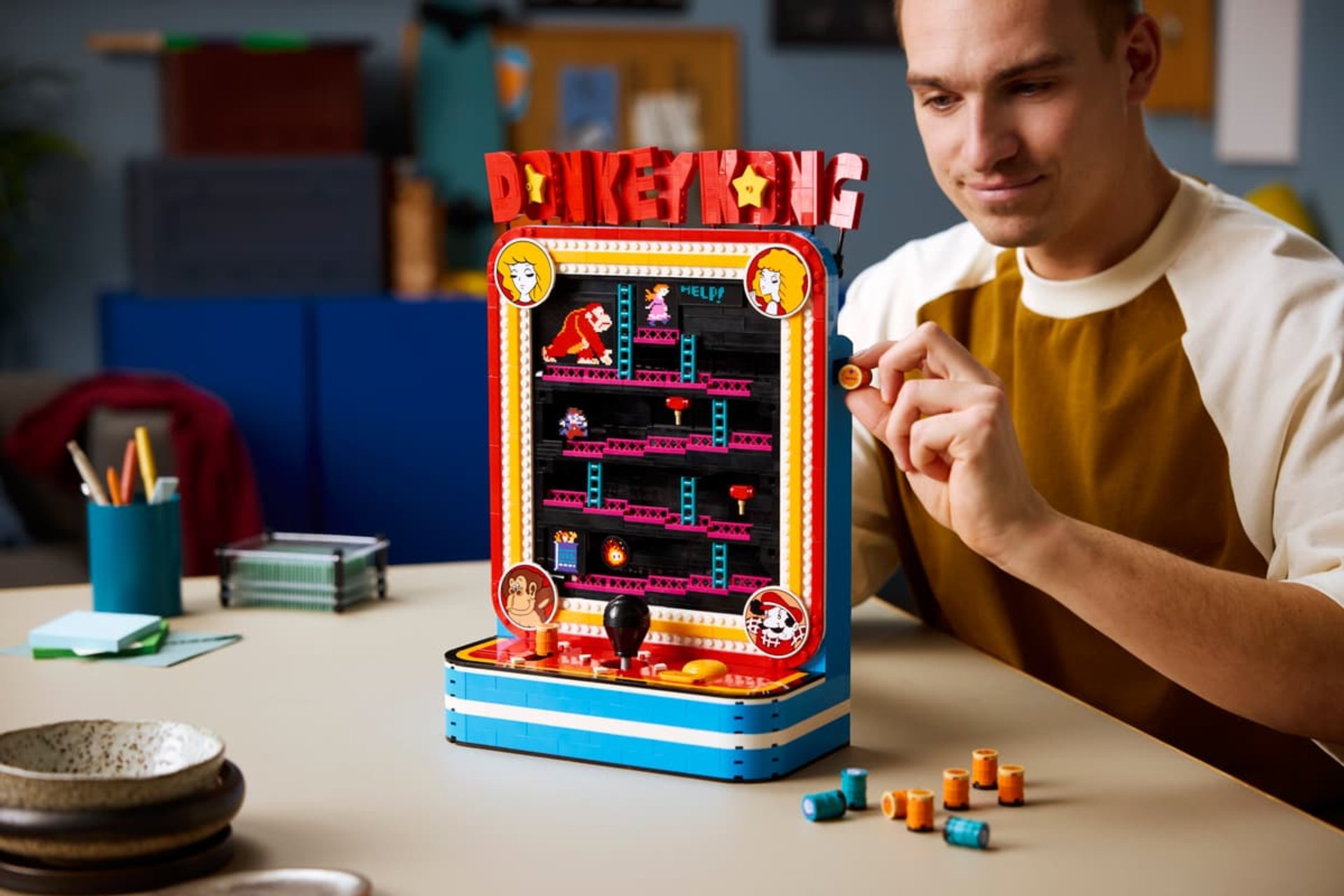 Donkey Kong Arcade Lego set on a table while a person plays with it.
