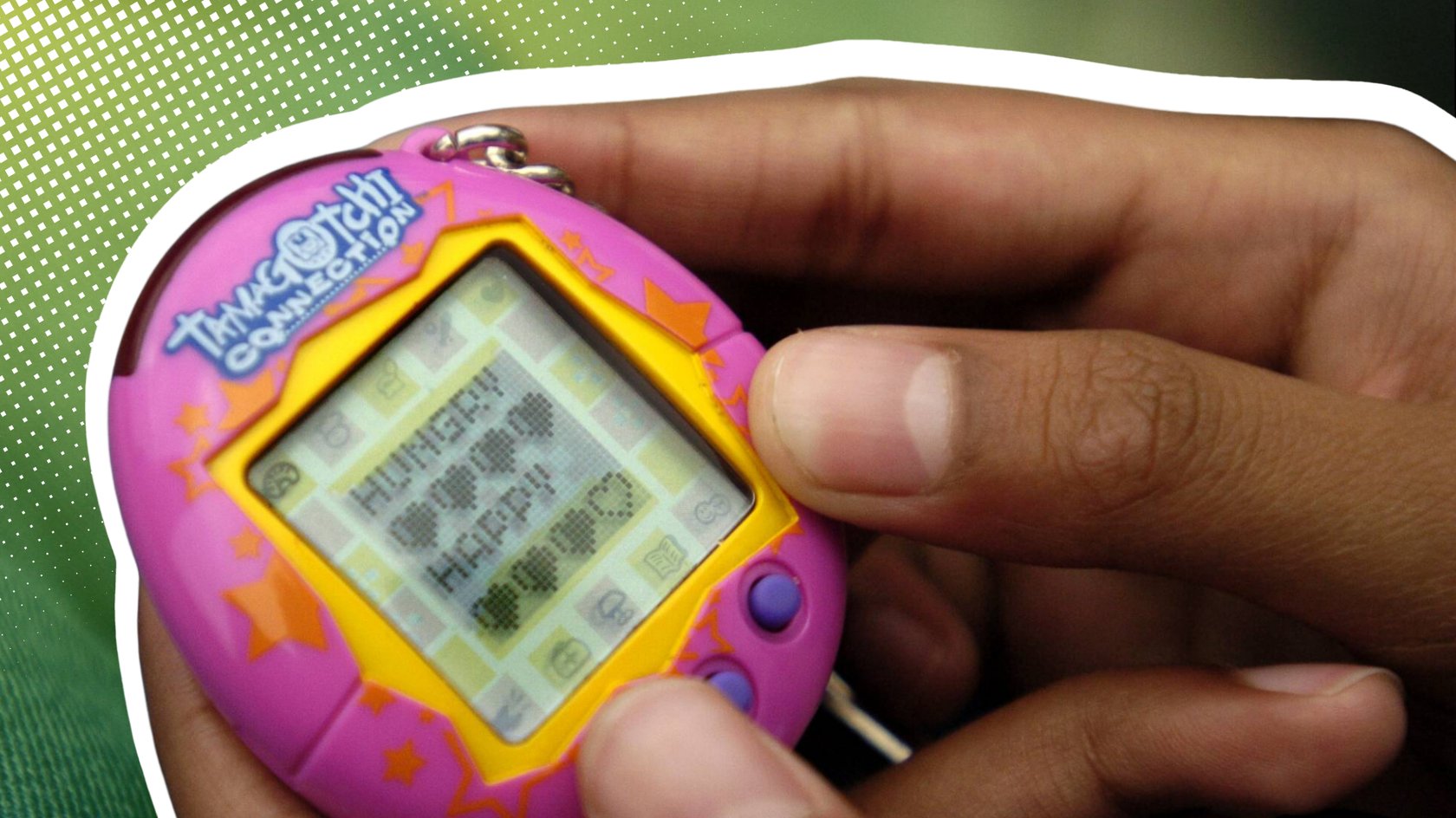 Jemand hält einen pinken Tamagotchi in der Hand.