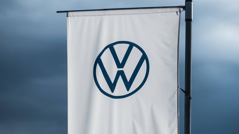 Volkswagenlogo vor dunklen Wolken.