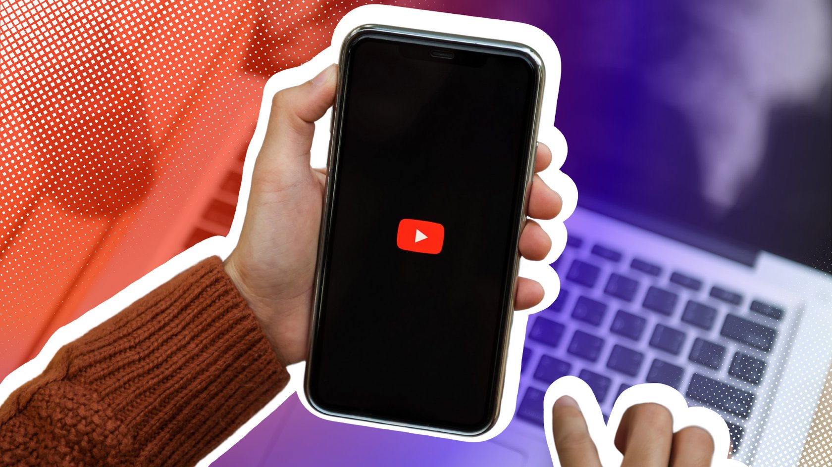 Nahaufnahme einer Person, die ein Smartphone mit dem YouTube-Logo in der Hand hält, während sie einen Laptop benutzt.