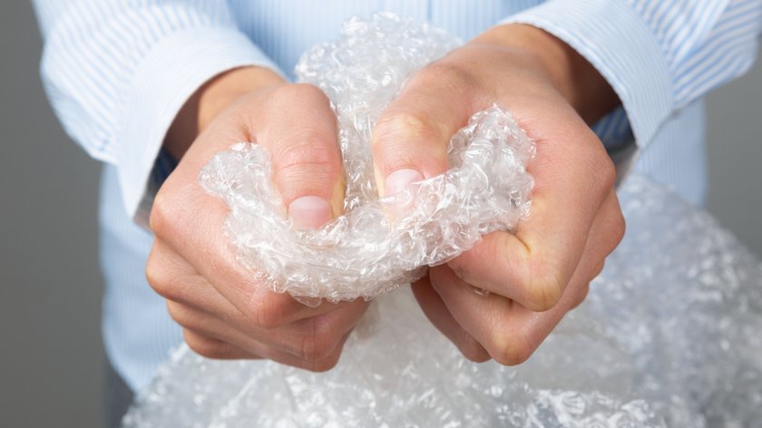 Female hands popping the bubbles of bubble wrap. Stress relief, anger management