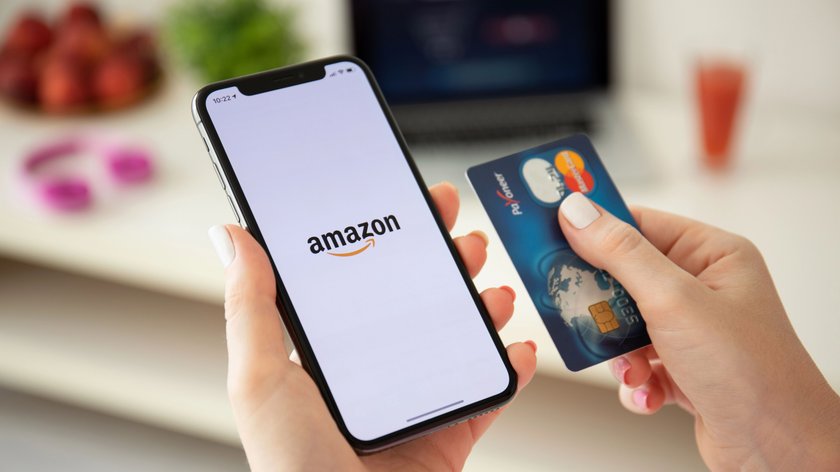 Ein iPhone mit Amazon-App neben einer Kreditkarte.