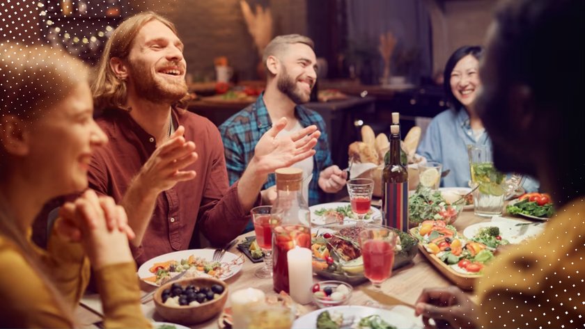 Freunde, die gemeinsam am Tisch essen und lachen.