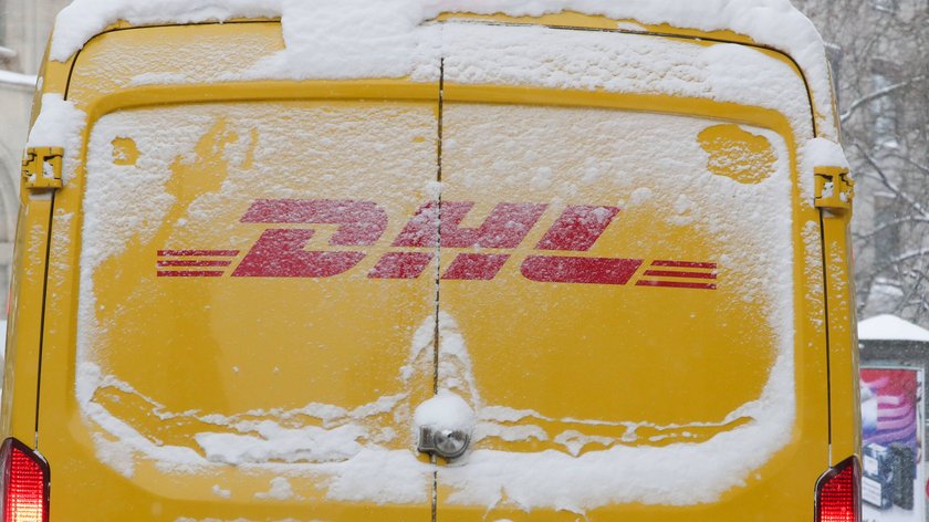 DHL Lieferwagen mit Logo im Schnee.