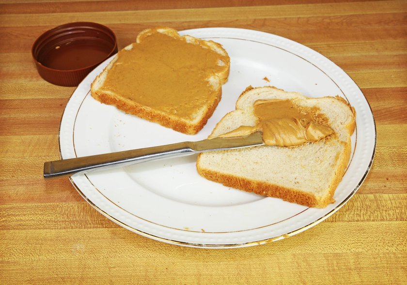 Spreading peanut butter on slices on a plate Copyright: BrandonxAxGibbs 32147791  RECORD DATE NOT STATED