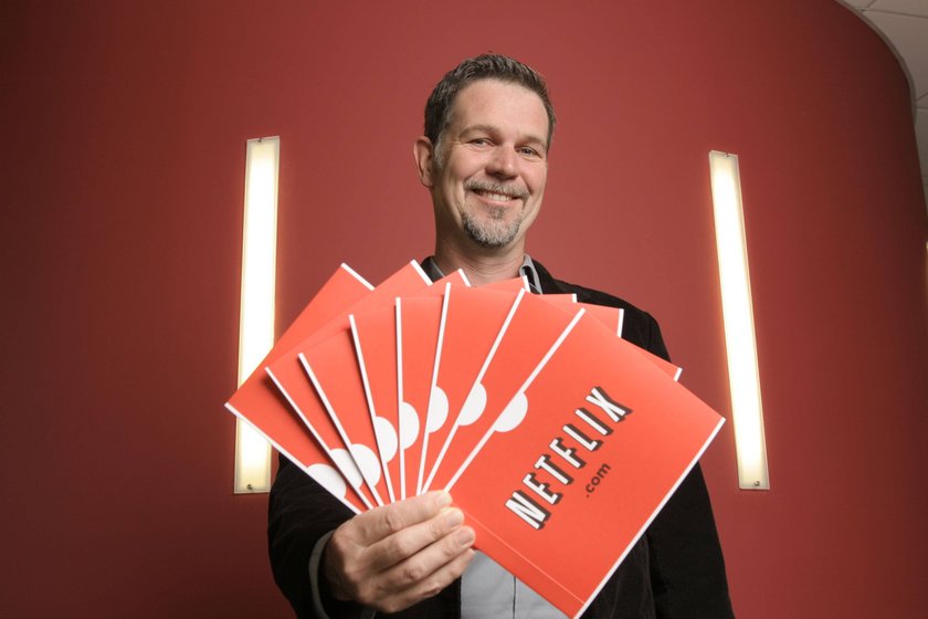 Reed Hastings hält Papiere mit Netflix-Logo