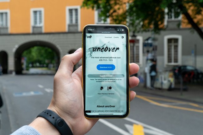 Foto einer Hand, die ein iPhone hält, auf dem eine Jailbreak-App angezeigt wird.