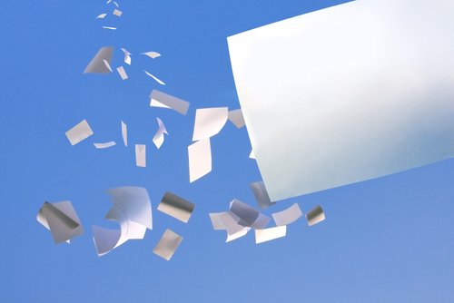 white paper falling from clear blue sky.