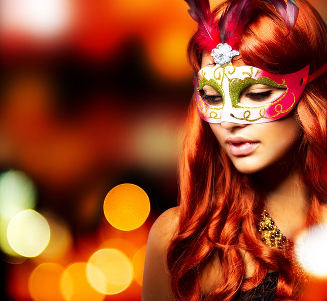 Masquerade. Beautiful Girl in a Carnival mask over Holiday Blinking Background. Bokeh