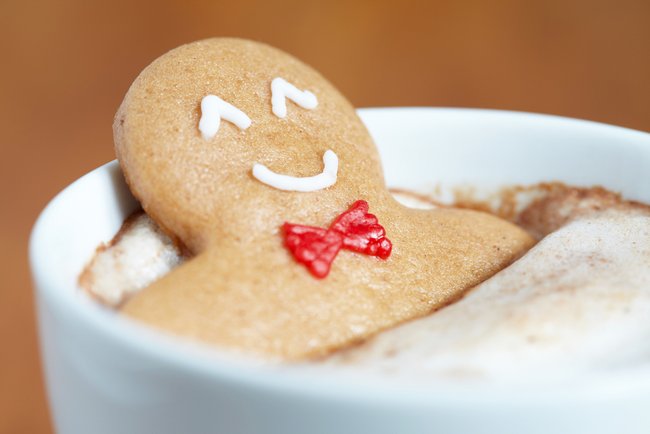 Gingerbread cookie man in a hot cup of cappuccino