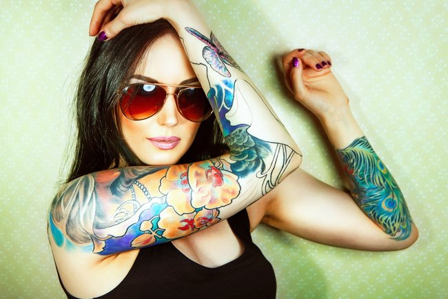 Beautiful girl with stylish make-up and tattooed arms