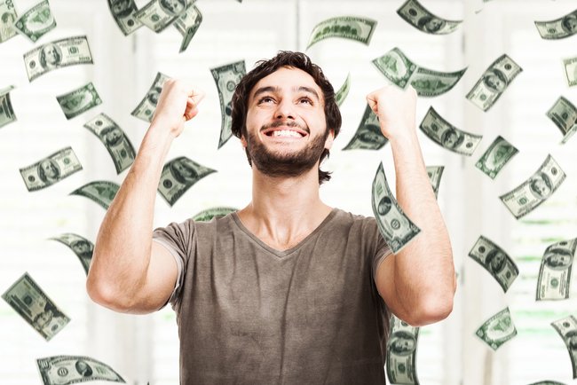 Portrait of a very happy young man in a rain of money