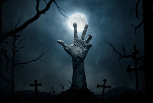 Das Halloween konzept der zombie entsteigt dem grab eine hand reckt sich aus dem aufgebrochenen erdboden