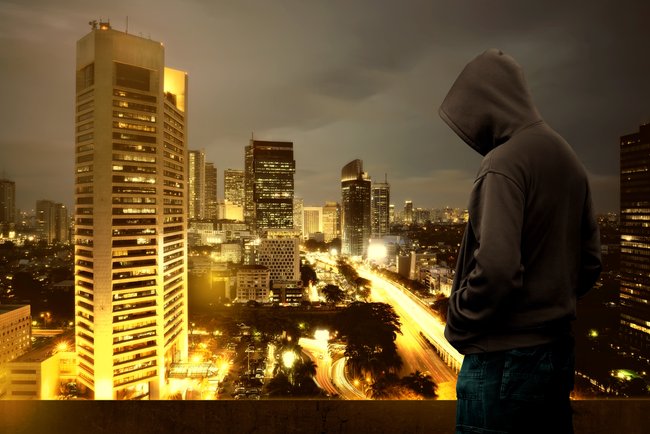 Hacker werden: Silhoutte eines Hackers vor der Stadtansicht