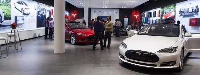 Tesla event screenshot von tesla zeigt einen autohandel der fiirma von innen mit kunden und modellen
