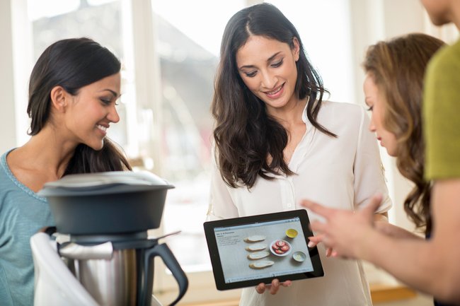 thermomix repräsentantin mit einem tablet und rezepten