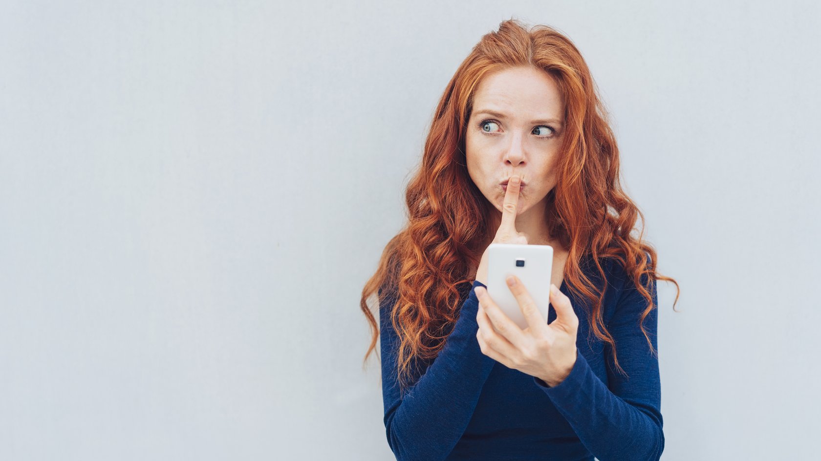 Frau mit Handy wundert sich