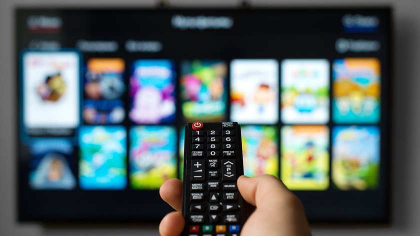 Hand mit Smart-TV-Fernbedienung