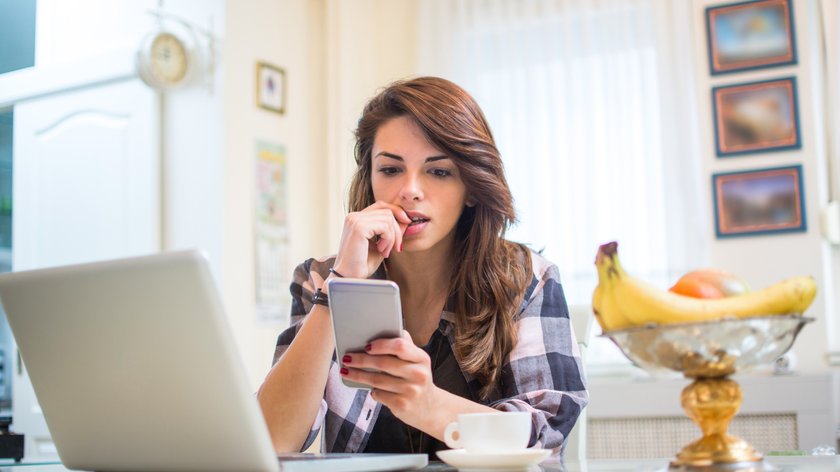 Frau mit Handy überlegt