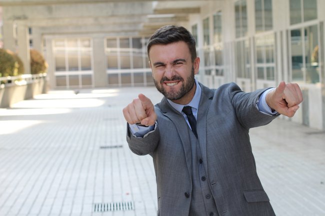Confident businessman pointing at camera