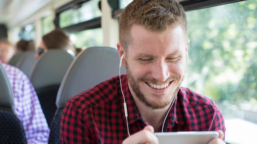 Man Watching Movie On Mobile Phone During Journey To Work