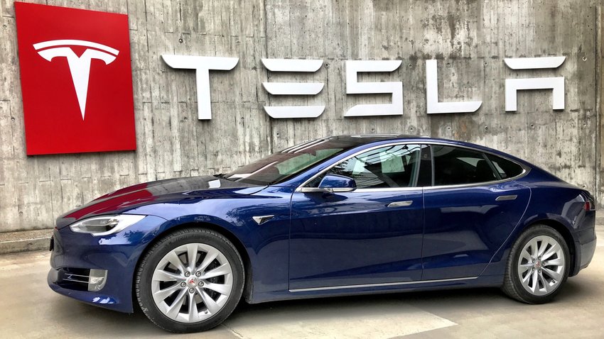 Tesla-Fahrzeug vor Tesla-Logo