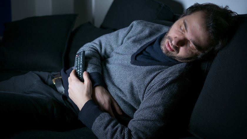 Mann schläft vor dem Fernseher