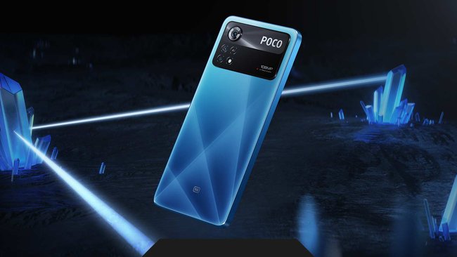 Vor einem dunklen Hintergrund ist die Rückseite des blauen Smartphones Xiaomi Poco X4 Pro zu sehen.