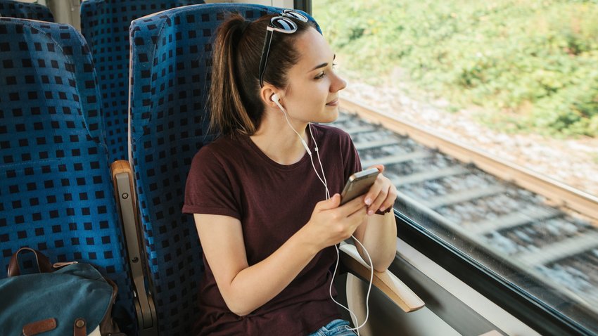 Junge Frau hört Musik im Zug