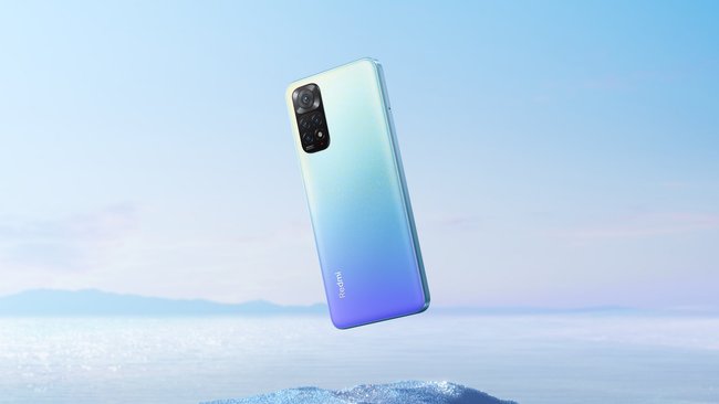 Against a light blue background is the light blue Xiaomi Redmi Note 11 smartphone.