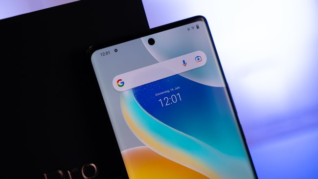 Das Smartphone Vivo X80 Pro steht mit aktiviertem Bildschirm gegen die Gerätepackung gelehnt.